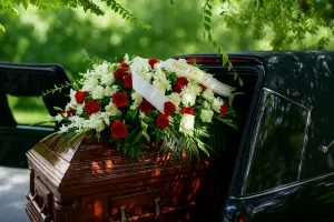 Grand drapé floral de roses rouges et blanches sur un cercueil lors des préparatifs des funérailles